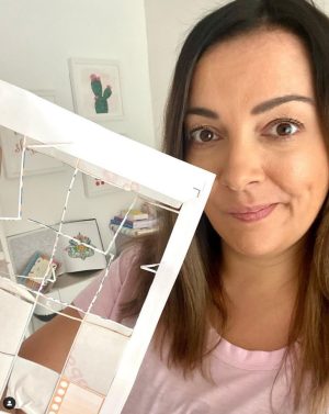 Mim Jenkinson is holding up a planner with miscut stickers